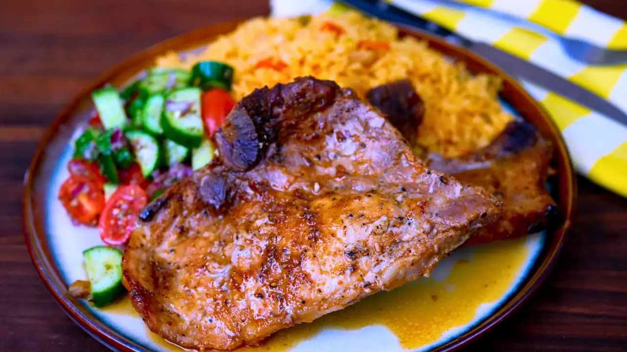 Juicy pork chops served with rice and fresh cucumber salad