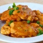 Authentic Puerto Rican bacalaitos (codfish fritters) garnished with sliced green onions on a white plate
