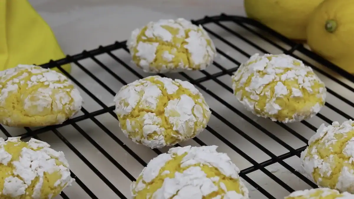 Soft lemon crinkle cookies cooling on a wire rack with fresh lemons