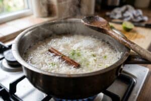 Rice simmering in pot with cinnamon stick for arroz con leche