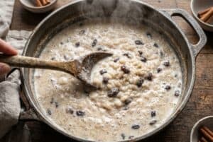 Arroz con leche simmering in pot with raisins and milk