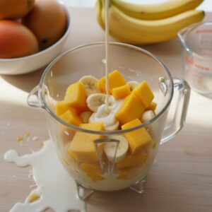 Tropical fruit being prepared and added to blender for Dominican batidos