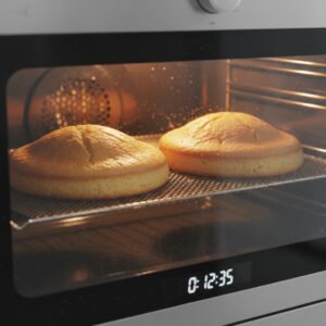 Bizcocho dominicano cakes baking in oven with golden tops
