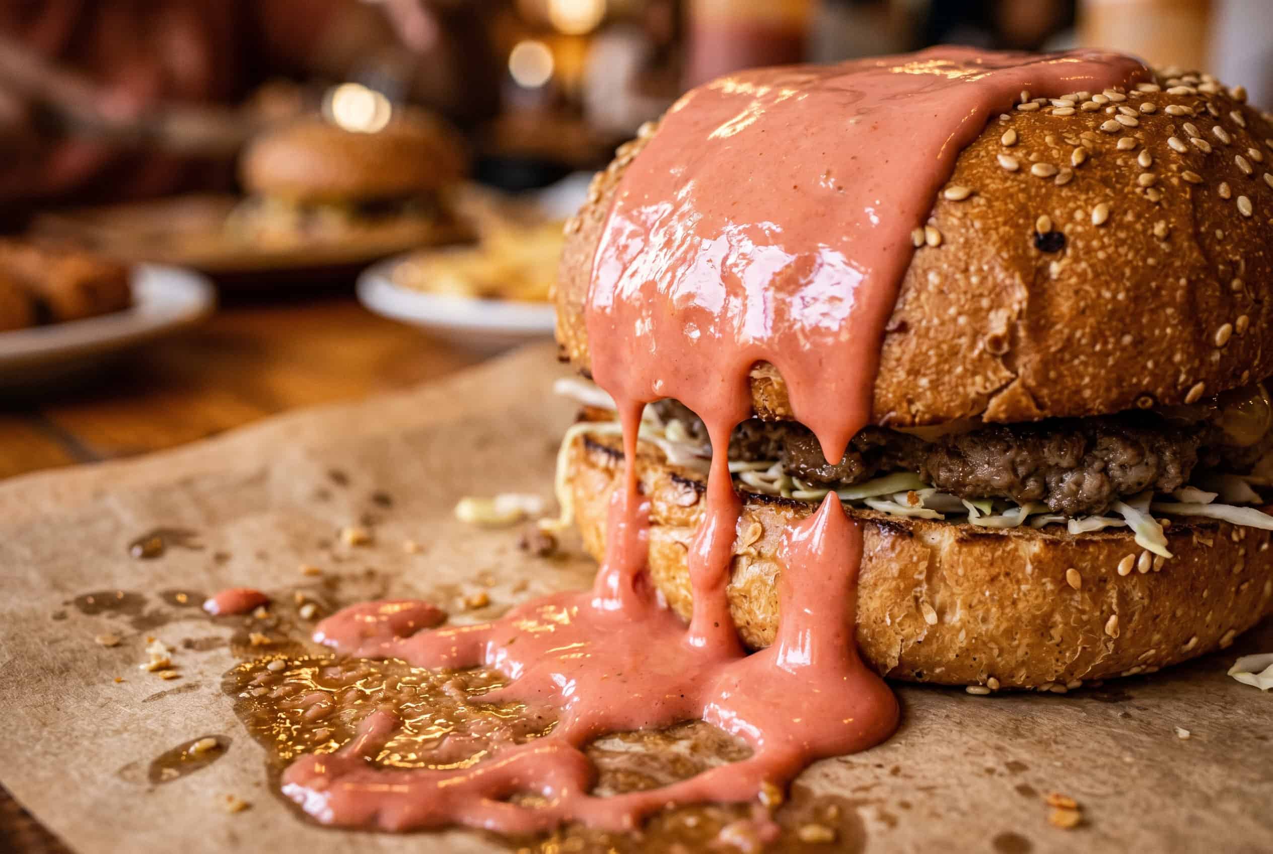 Pink mayoketchup sauce dripping down Dominican chimi burger