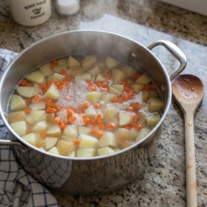 Potatoes and carrots being boiled for Dominican ensalada rusa