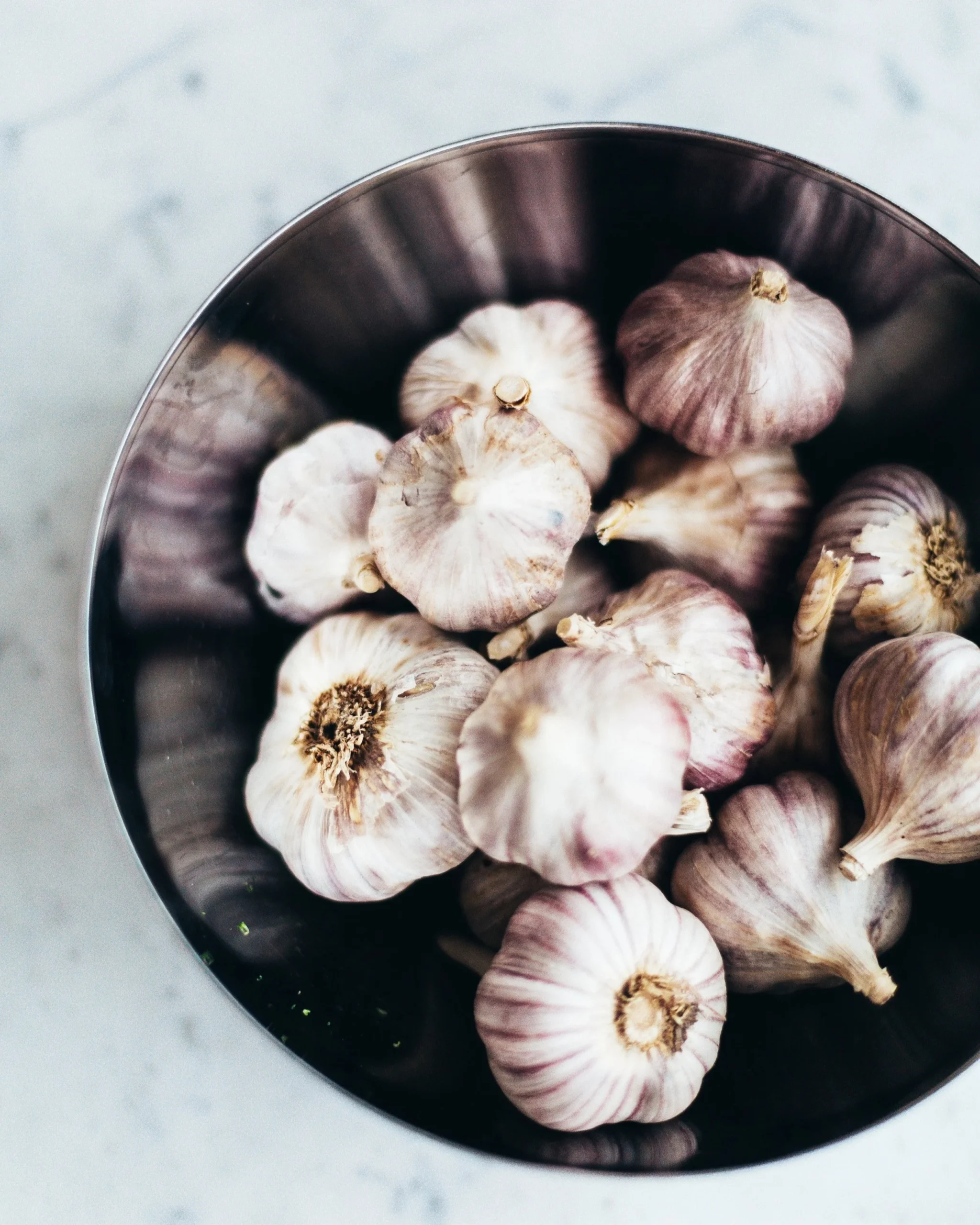 Garlic bulbs in a stainless steel bowl