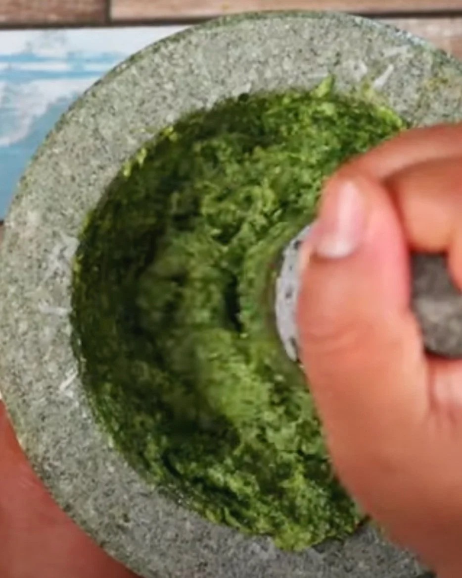 Hand grinding herbs in mortar