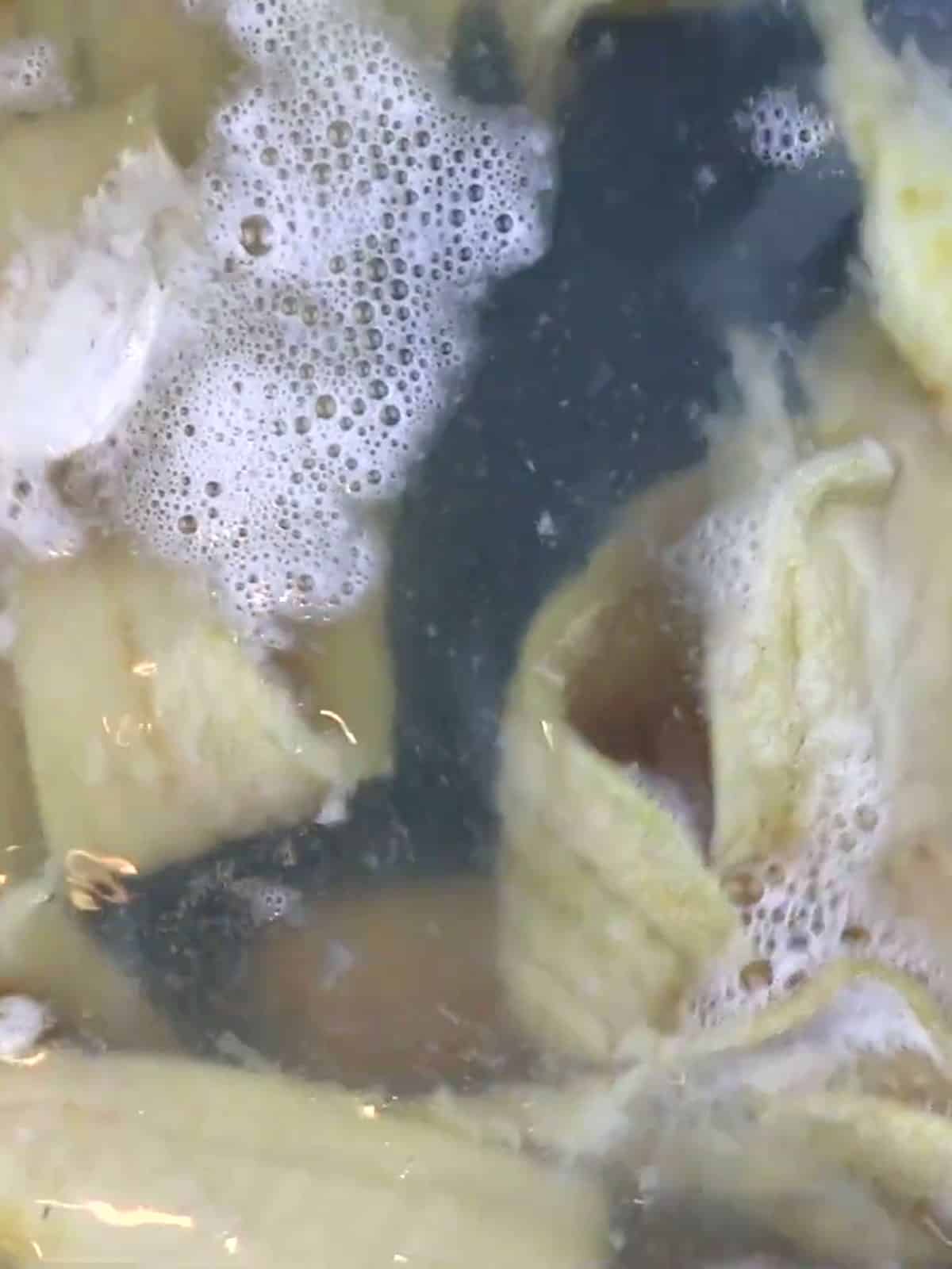 Guanimos boiling in banana leaves in a large pot