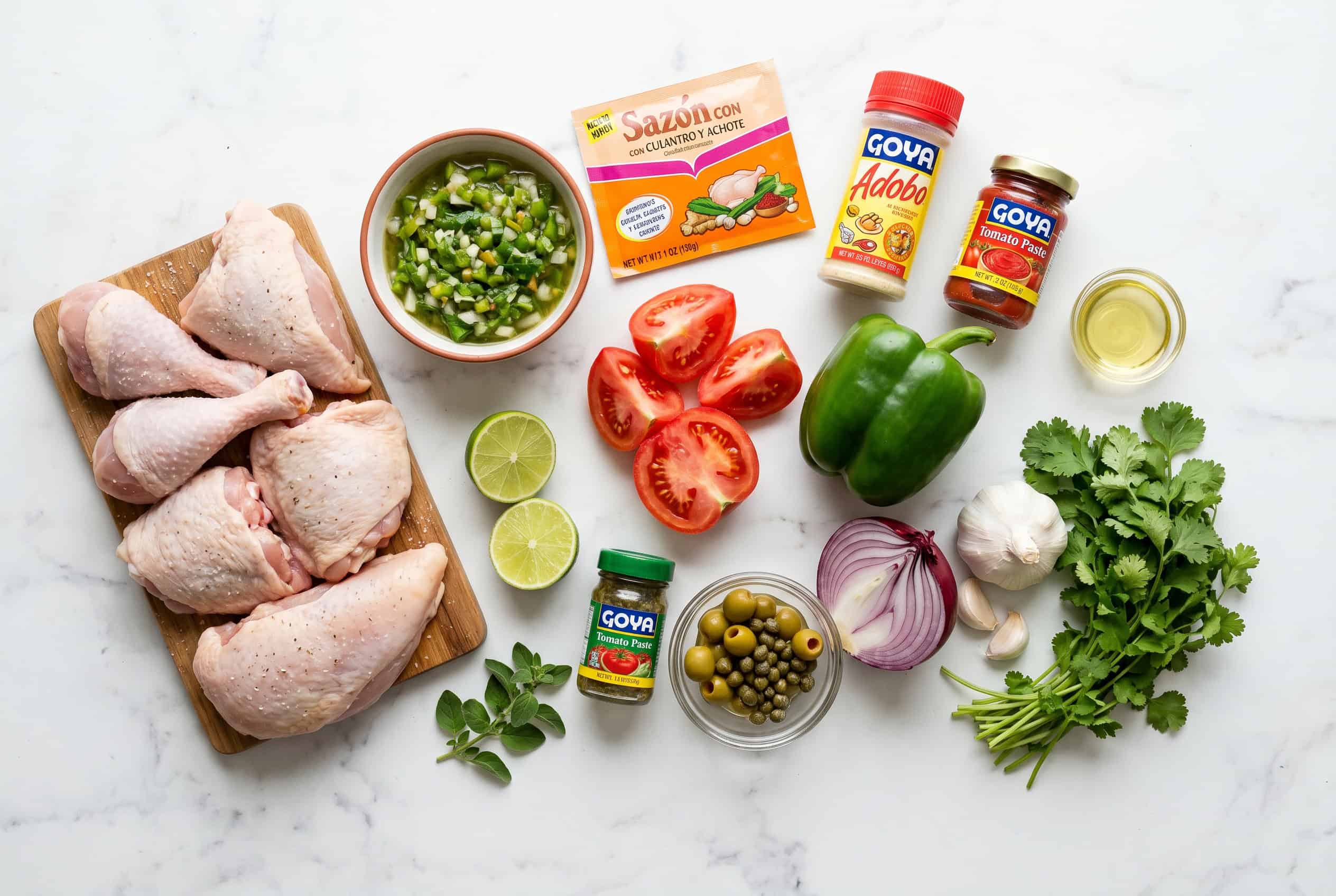 Overhead flat lay of raw ingredients for Dominican pollo guisado