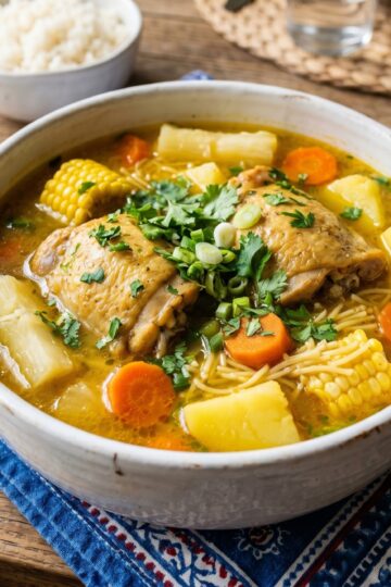 Dominican sopa de pollo chicken soup in white bowl with yuca carrots and noodles