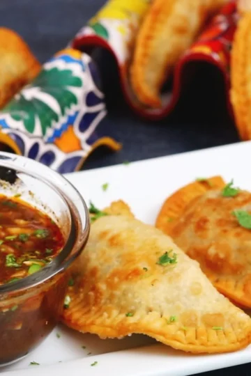Super cheesy beef birria empanadas served with consomme for dipping