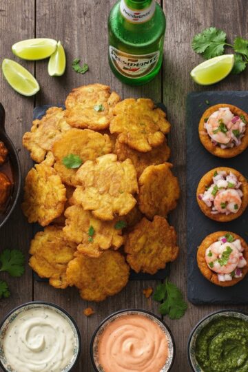 Dominican tostones spread with garlic mojo, pollo guisado, ceviche-topped tostones rellenos, and ice-cold Presidente beer