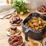 Golden crispy air fryer chicken wings in the basket surrounded by air fried tostones, ribs, whole chicken, pork belly, steak, and more — Kelvin's Kitchen air fryer recipes.