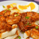 Korean Gochujang Shrimp with Crispy Rice Cakes and Jammy Eggs Korean gochujang shrimp with crispy rice cakes and a jammy soft-boiled egg, topped with sesame seeds and green onion