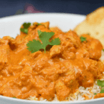Slow Cooker Chicken Tikka Masala Slow cooker chicken tikka masala in a creamy tomato sauce served over basmati rice with naan and fresh cilantro