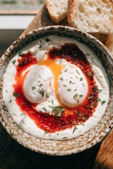 Turkish eggs çılbır — poached eggs on garlicky yogurt with Aleppo pepper butter and crusty bread